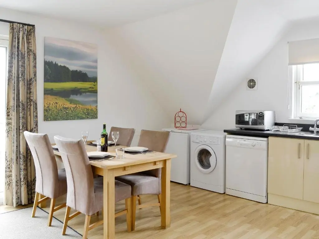 a kitchen and dining room with a table and chairs at 22 Queens Court in Inchmarlo