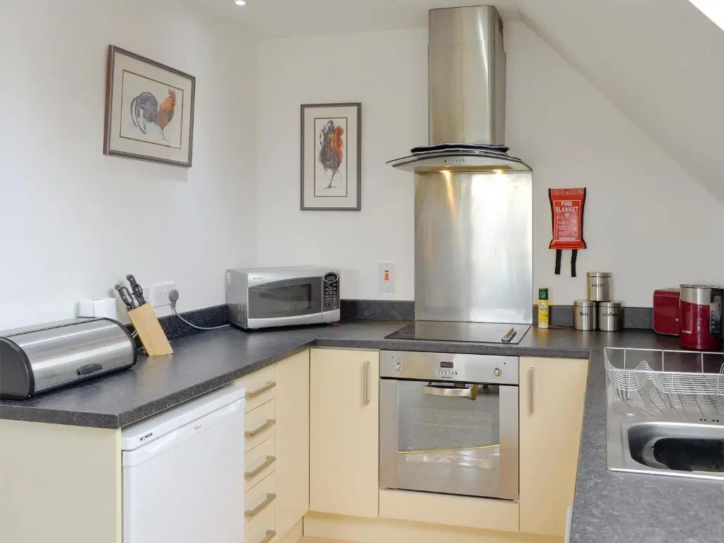 a kitchen with a stove and a microwave at 32 Queens Court in Inchmarlo