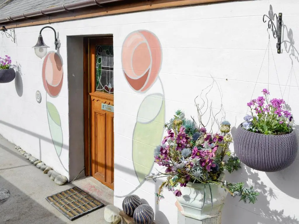 a house with two flower pots on the side of it at Sea Yonder in Buckie