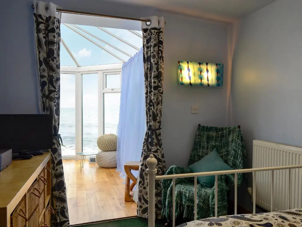 a bedroom with a bed and a sliding glass door at Sea Yonder in Buckie