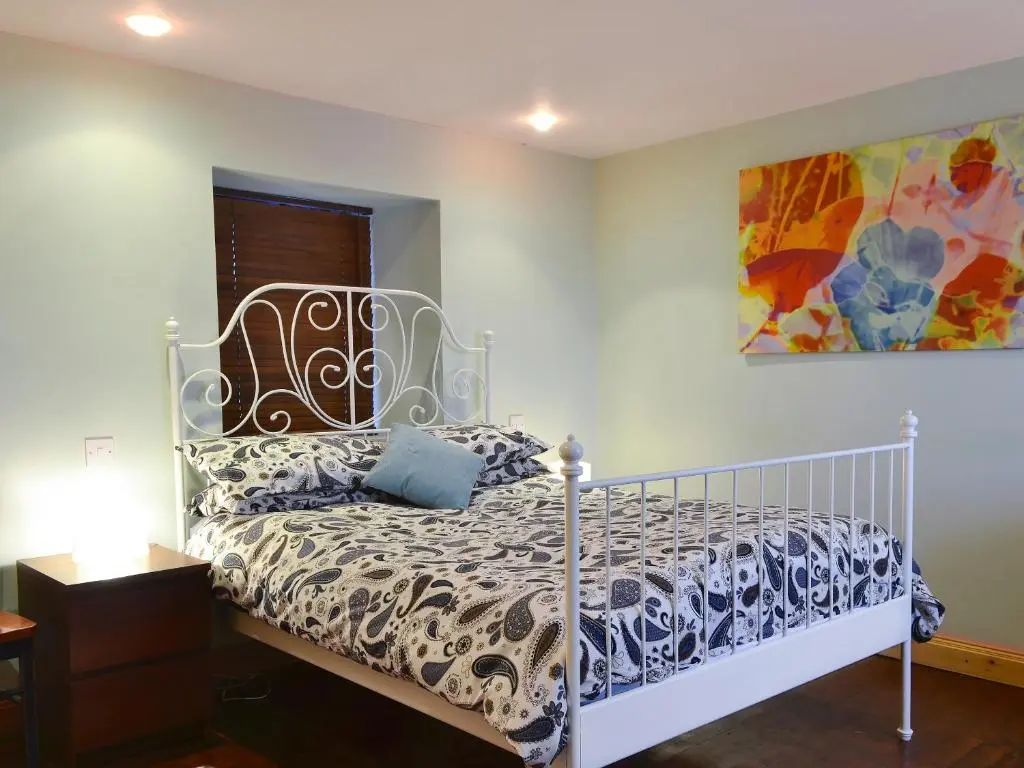 a bedroom with a bed and a painting on the wall at Sea Yonder in Buckie