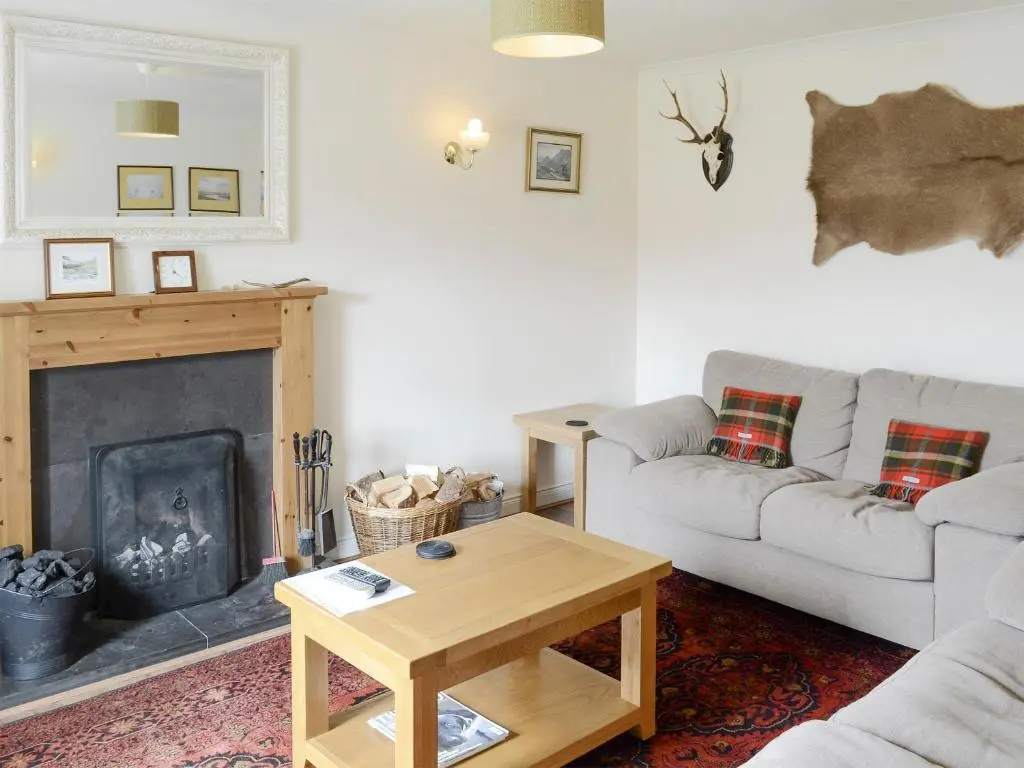 a living room with a couch and a fireplace at Keeper's House in Glenrossal