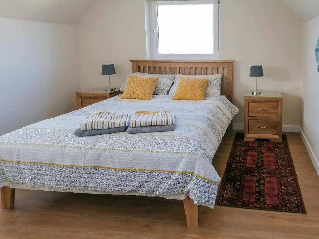 a bed with two pillows on it in a bedroom at Rosslyn Cottage in Portmahomack