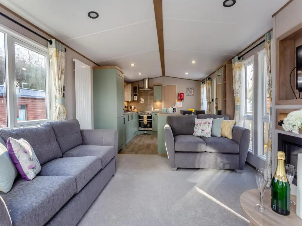 a living room with two couches and a kitchen at The Pines in Aviemore