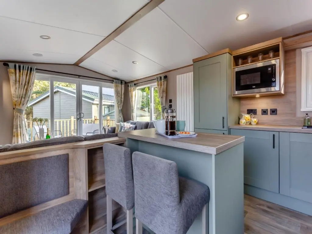 an open kitchen with a bar and chairs in a house at The Pines in Aviemore