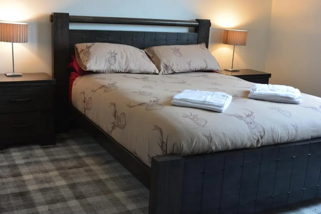a bedroom with a bed with two towels on it at Whitehouse B&B in Fort Augustus