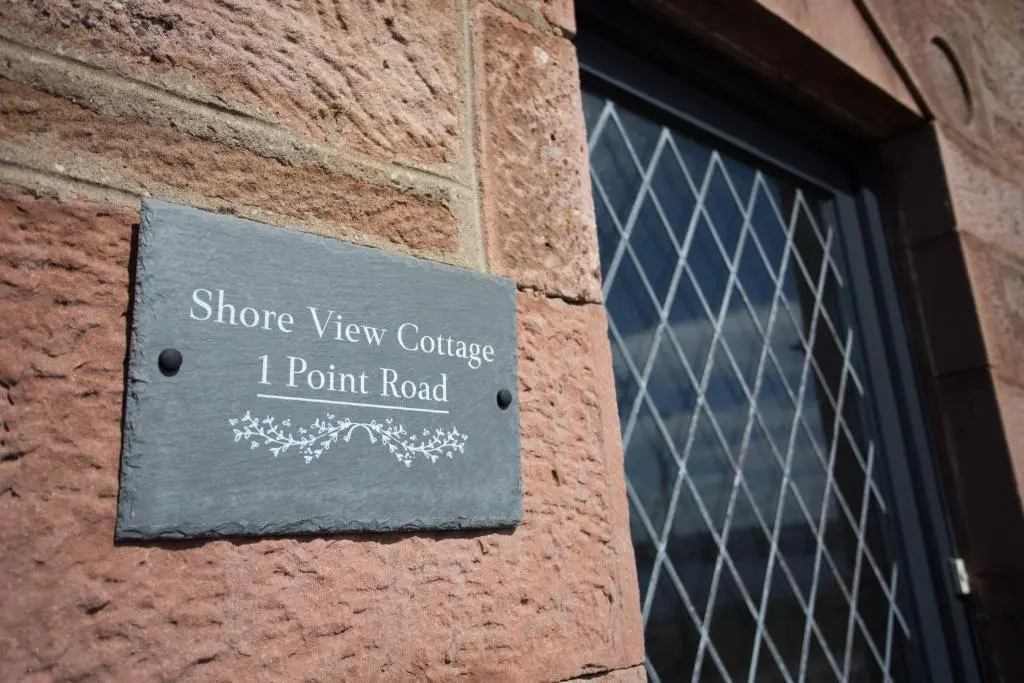 a sign on the side of a brick building at Shore View Cottage in Inverness