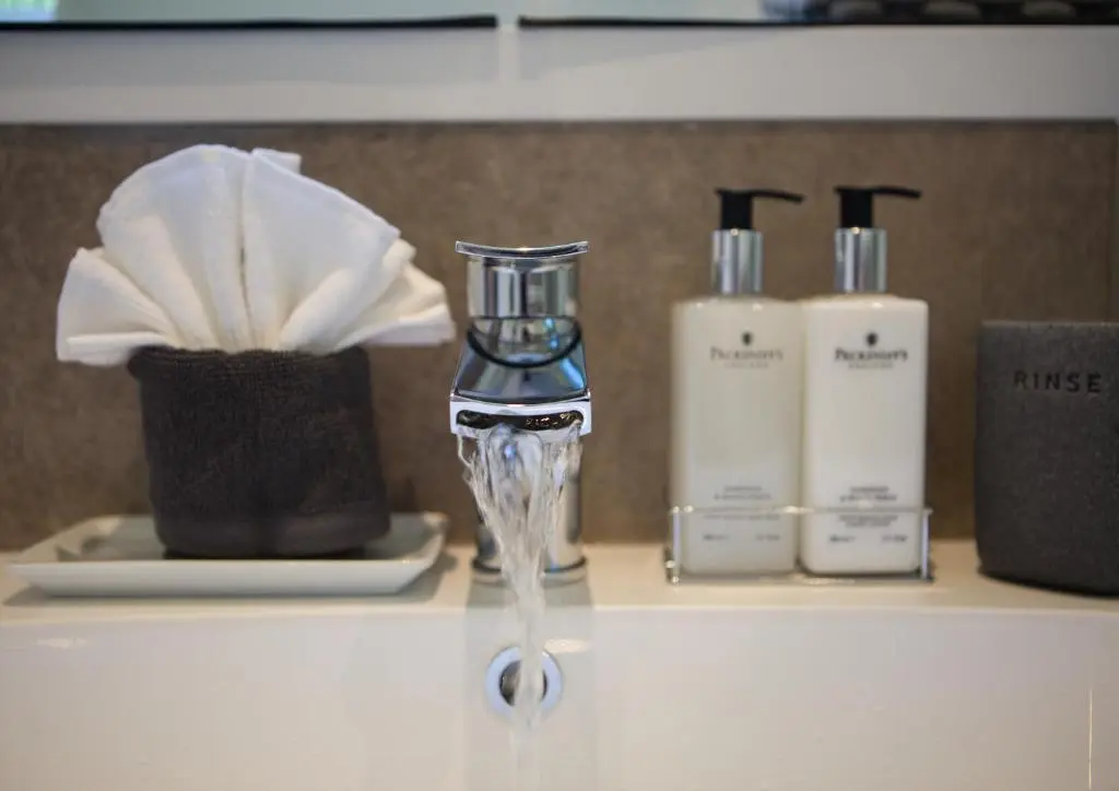 a bathroom counter with a blow dryer and bottles of soap at Shore View Cottage in Inverness