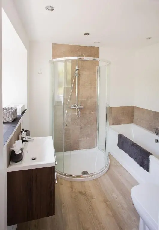 a bathroom with a shower and a toilet and a sink at Shore View Cottage in Inverness