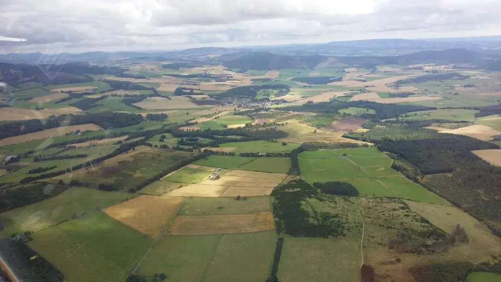 an aerial view of green fields and trees at Deeside Holiday Cottages in Dinnet