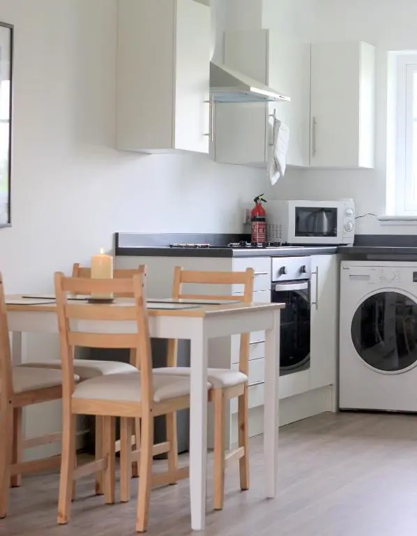 a kitchen with a table and chairs and a microwave at Ventoux in Aviemore