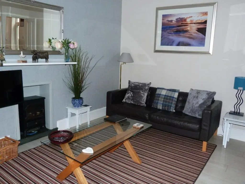 a living room with a couch and a coffee table at Wee Ness Cottage in Inverness