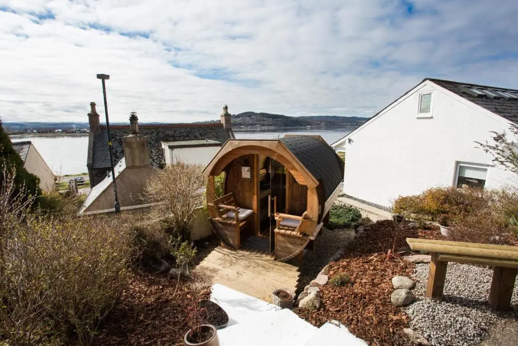 a house with a wooden archway in a yard at Fishermans in Inverness