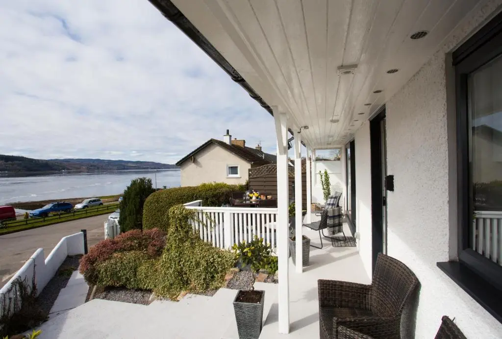 a porch with chairs and a view of the water at Fishermans in Inverness