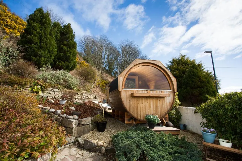 a small wooden hobbit house in a garden at Fishermans in Inverness