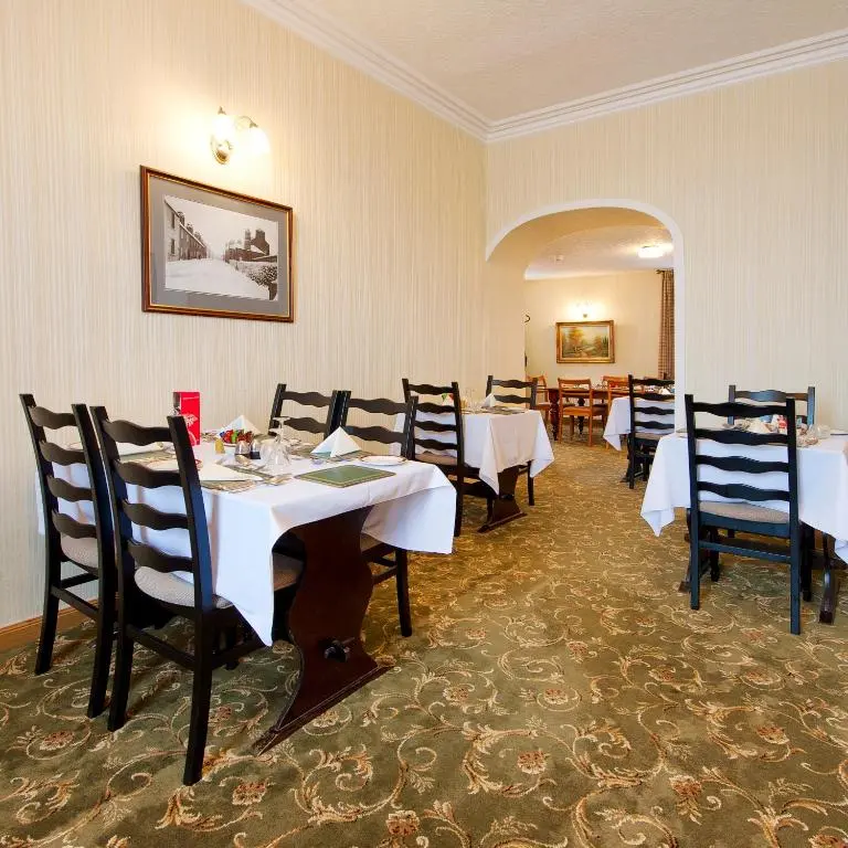 a dining room with white tables and chairs at Nethercliffe Hotel in Wick