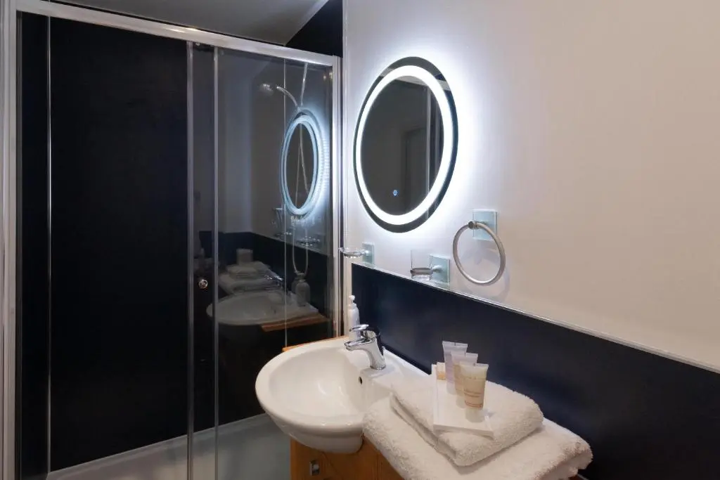 a bathroom with a sink and a shower and a mirror at Tigh na Lochan in Aviemore