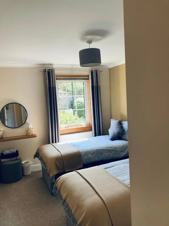 a bedroom with two beds and a window at Apartment 101 Kingsmills Road in Inverness
