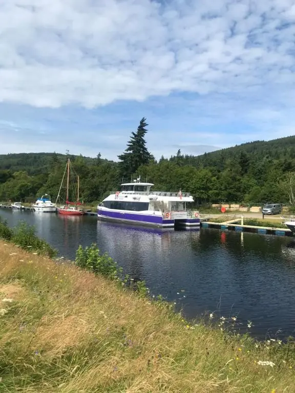 a boat is docked at a dock on a river at Apartment 101 Kingsmills Road in Inverness