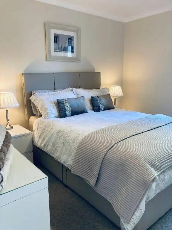 a bedroom with a large bed with two lamps at Apartment 101 Kingsmills Road in Inverness