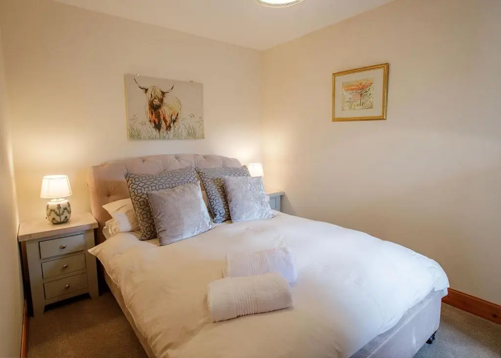 a bedroom with a large white bed in a room at The Old Dairy in Lairg