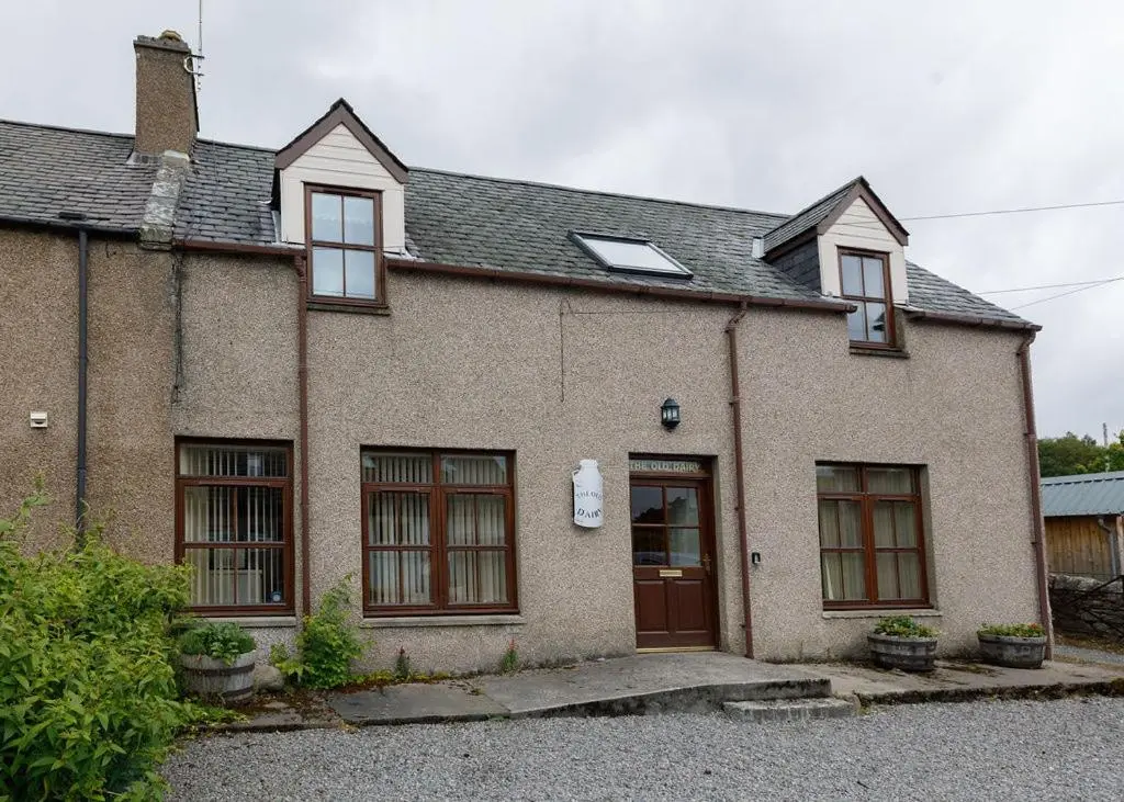 an old brick house with a door and windows at The Old Dairy in Lairg