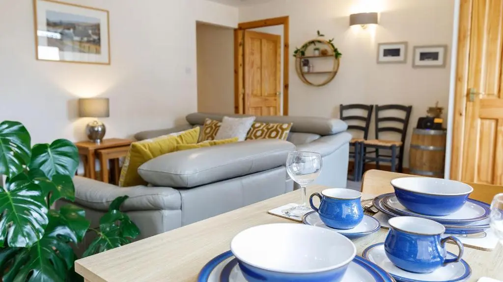 a living room with a table with blue and white dishes on it at The Old Dairy in Lairg