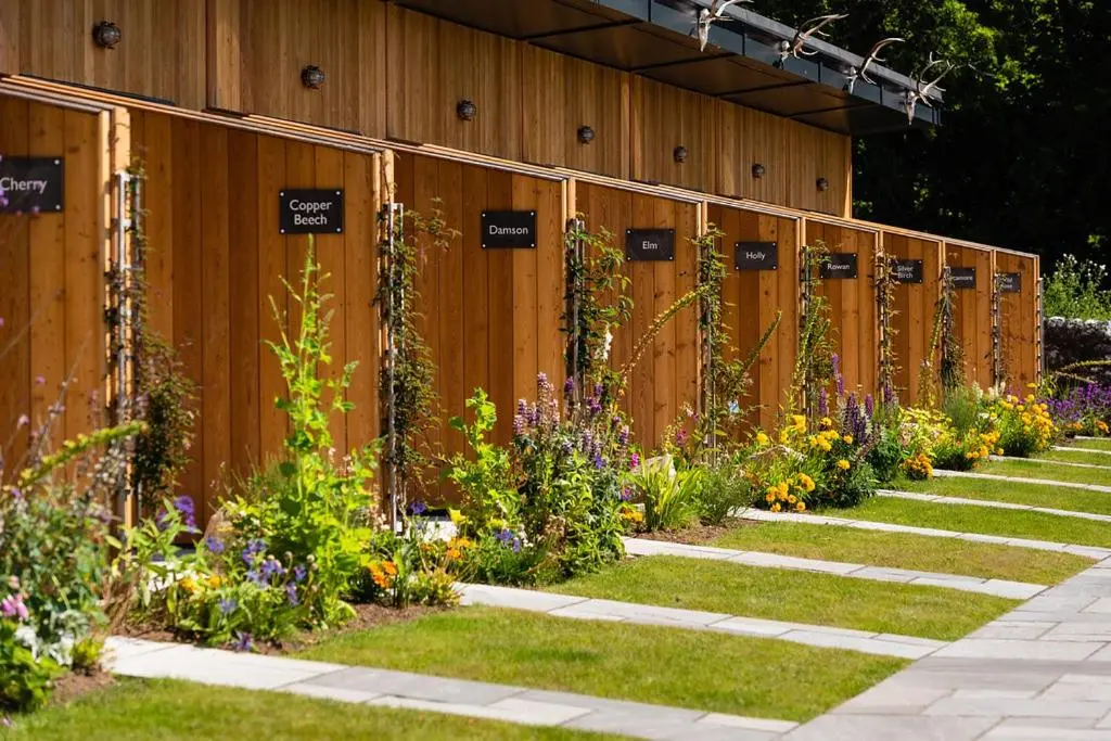 a row of wooden fences with flowers on them at The Old Manse of Blair, Boutique Hotel & Michelin Restaurant in Blair Atholl