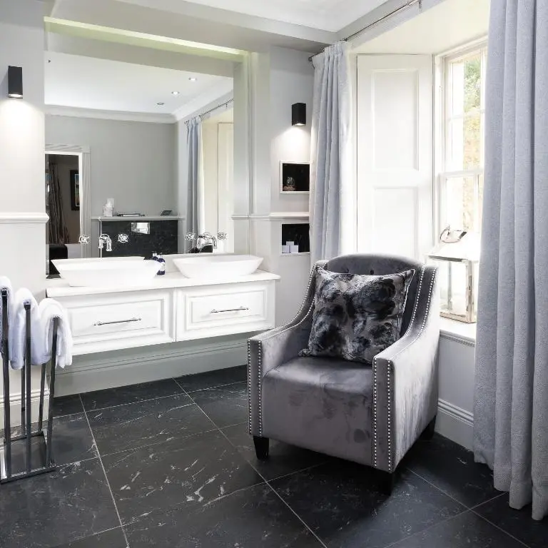a bathroom with a tub and a chair and a sink at The Old Manse of Blair, Boutique Hotel & Michelin Restaurant in Blair Atholl