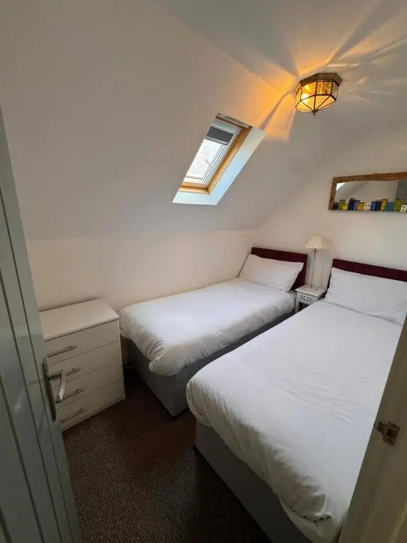 two beds in a small room with a window at Seaforth Cottage -Dog friendly, Historical Fishertown, central location in Nairn