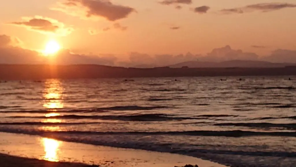 a sunset on the beach with the ocean at Seaforth Cottage -Dog friendly, Historical Fishertown, central location in Nairn