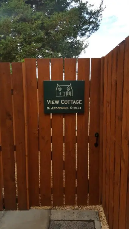 a wooden fence with a sign on it at View Cottage in Inverness