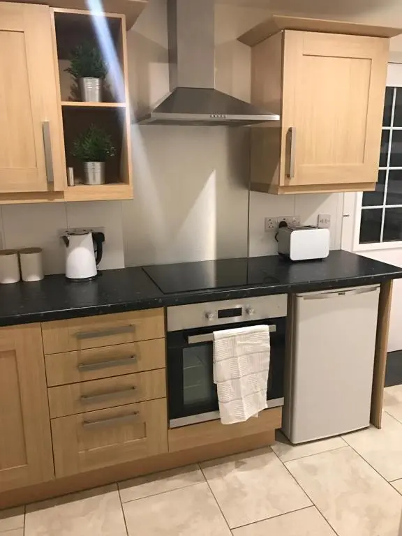 a kitchen with a black counter top and wooden cabinets at View Cottage in Inverness