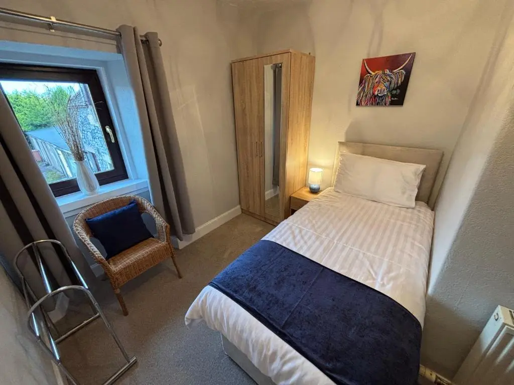 a small bedroom with a bed and a window at The Coffee Pot accommodation in Dufftown