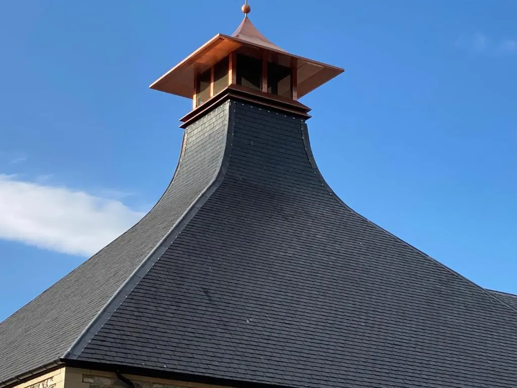 a black roof of a building with a cross on it at The Coffee Pot accommodation in Dufftown