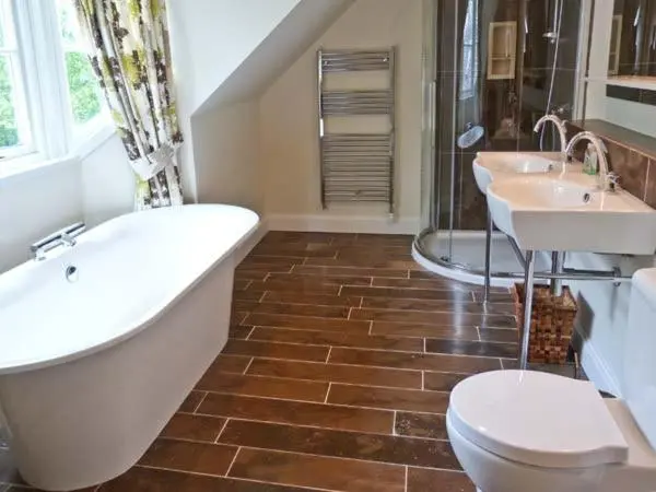 a bathroom with a tub and two sinks and a toilet at Easter Urray Farmhouse in Muir of Ord