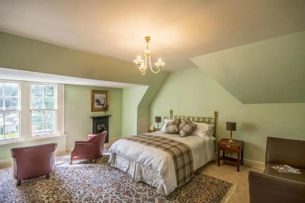 a bedroom with a bed and a chandelier at Blervie House in Forres