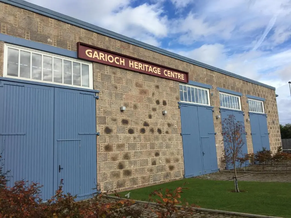 a brick building with blue doors and a sign on it at The Sidings Inverurie in Inverurie