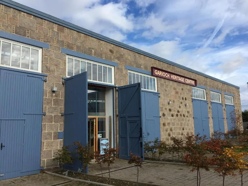 a brick building with blue doors and a sign on it at The Sidings Inverurie in Inverurie