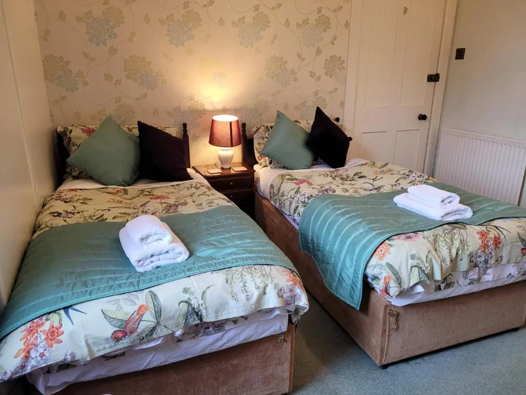 two beds sitting next to each other in a room at Dunallan Guest House in Grantown on Spey