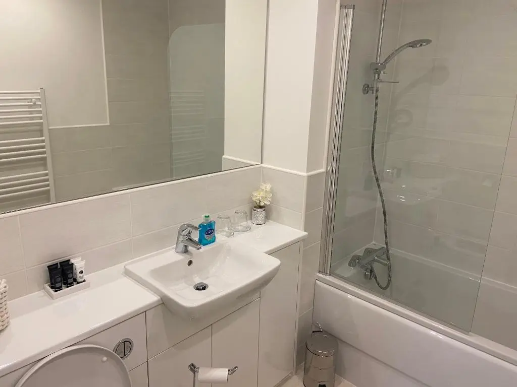 a white bathroom with a sink and a shower at 23 Hedgefield House in Inverness