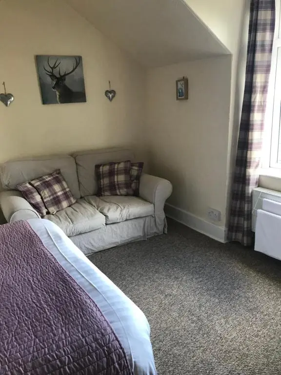 a living room with a couch and a bed at Foyers Roost in Foyers
