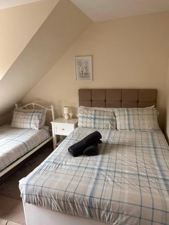 a bedroom with a bed with a hat on it at Rose Cottage in Inverness