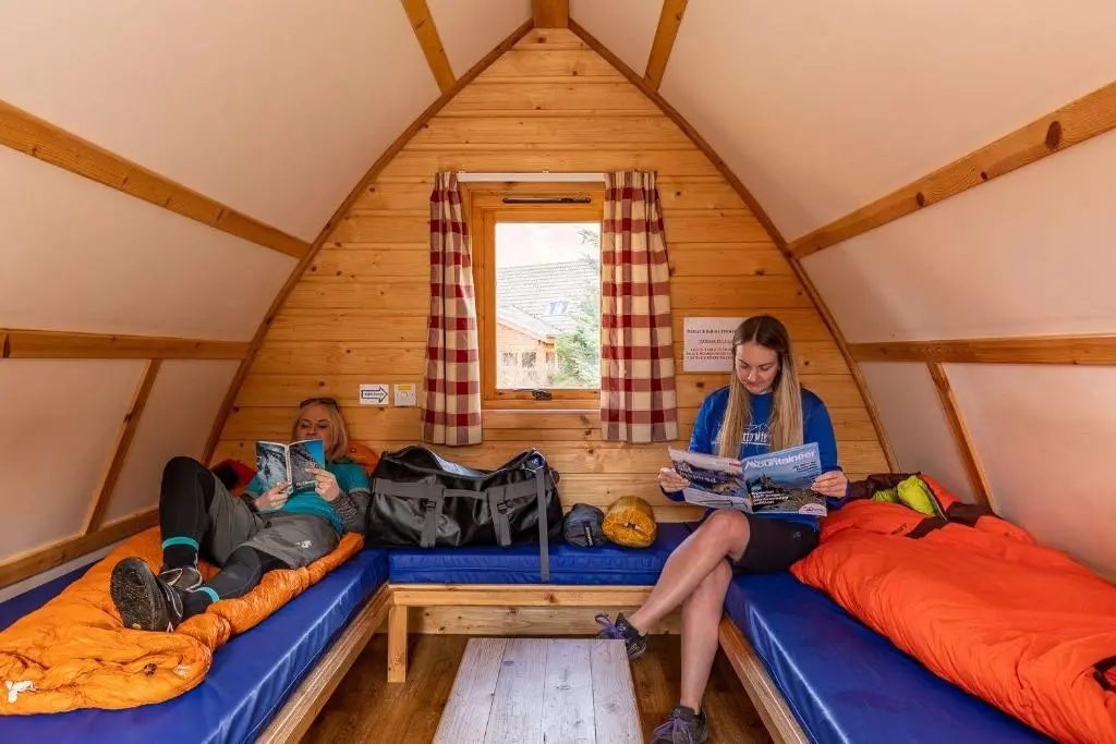 two women sitting on beds in a igloo at Badaguish forest lodges and camping pods in Aviemore