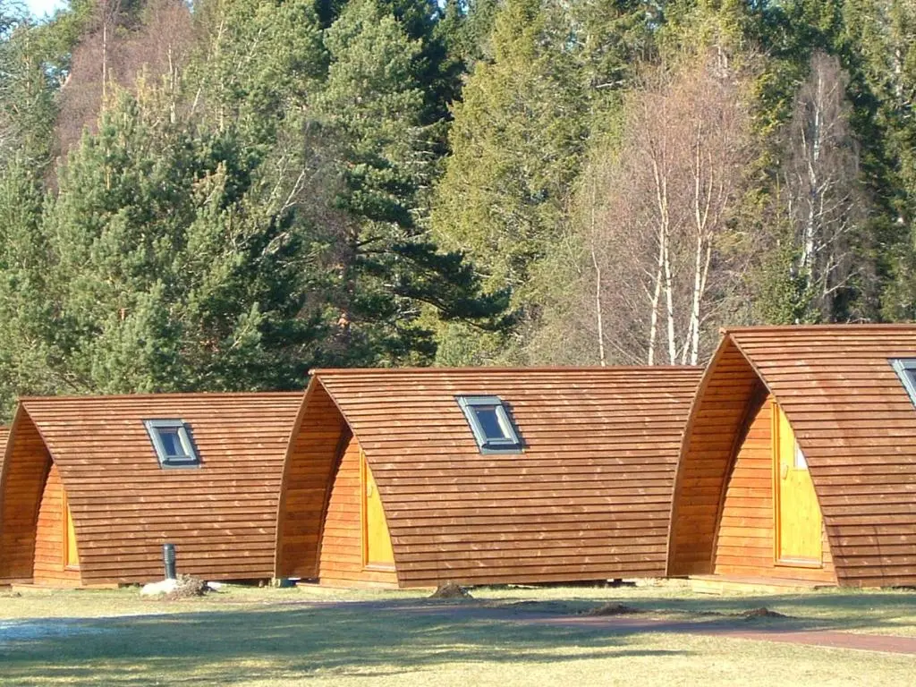 a building with three windows on the side of it at Badaguish forest lodges and camping pods in Aviemore