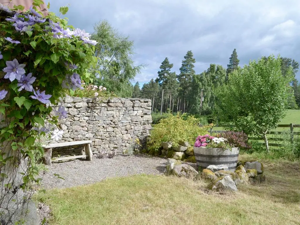 a stone wall and a bench in a garden at St Orans in Rafford