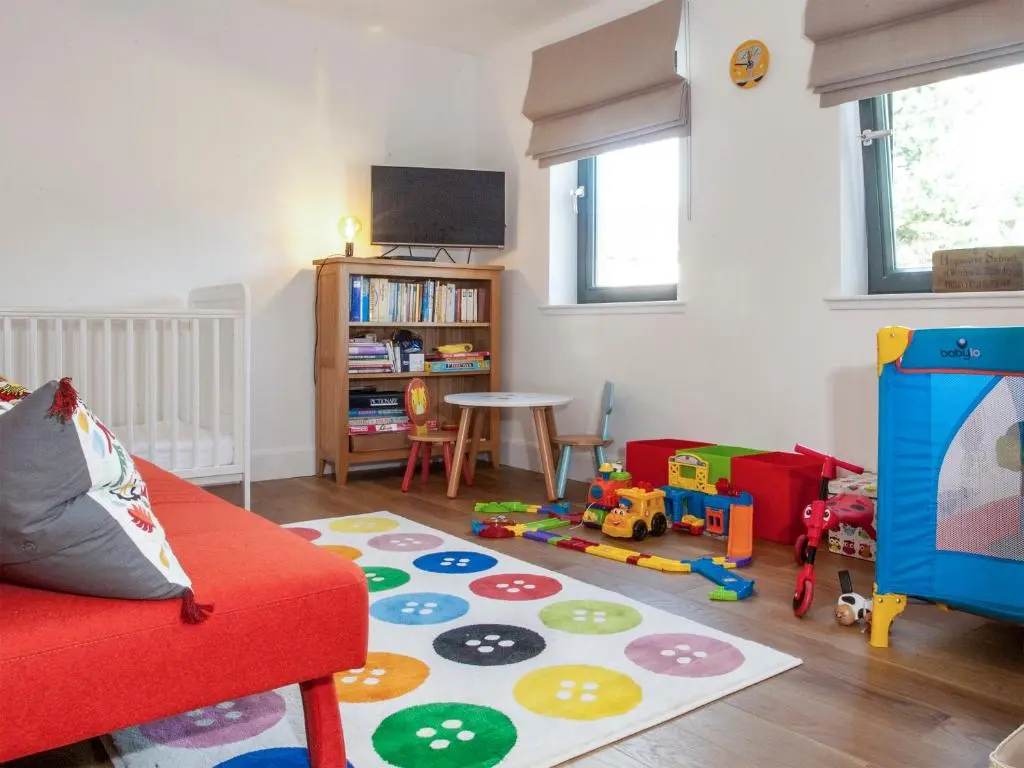 a living room with a red couch and toys in it at Strathspey Lodge in Duthil