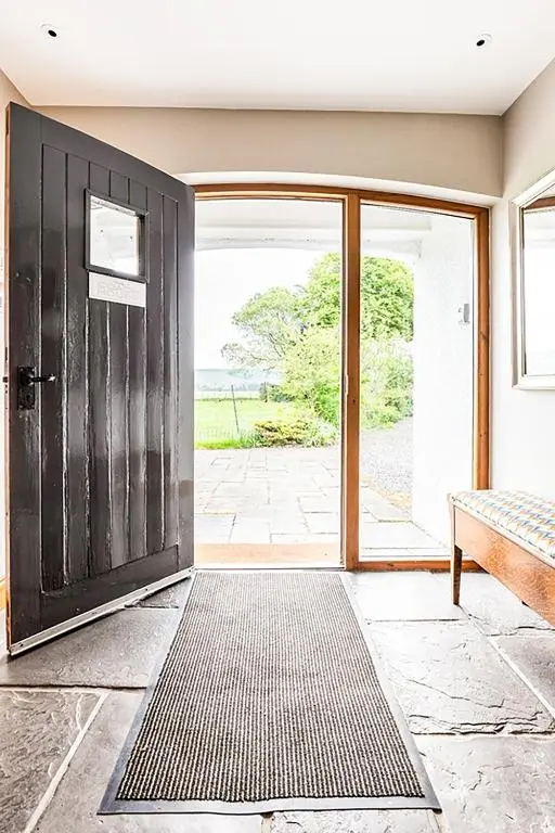 an open door leading to a patio with a bench at Coach House at Soilzarie in Blairgowrie