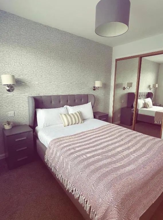 a bedroom with a large bed and a large mirror at Malva - Modern 2 Bedroom Bungalow in Wick Sleeps 4 with private parking - NC500 Route in Wick
