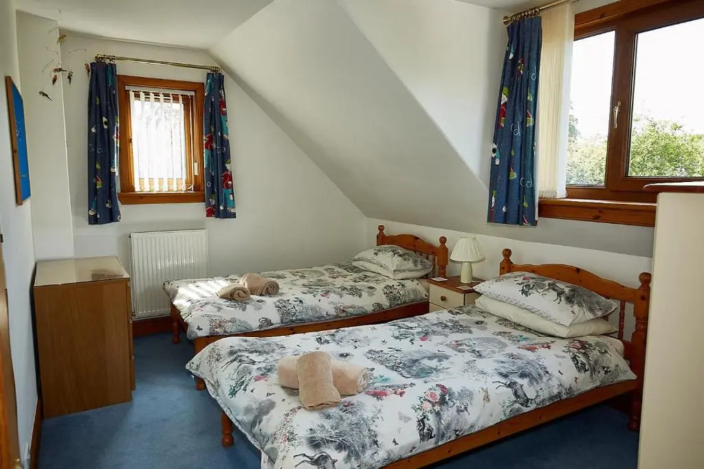 a bedroom with two beds with teddy bears on them at Rowans Inverness in Inverness